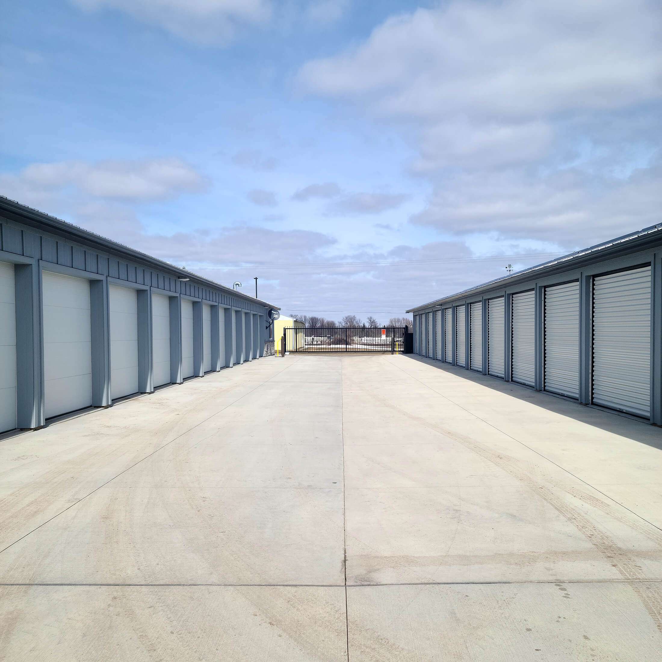 gate at the end of a wide aisle between drive up self storage units