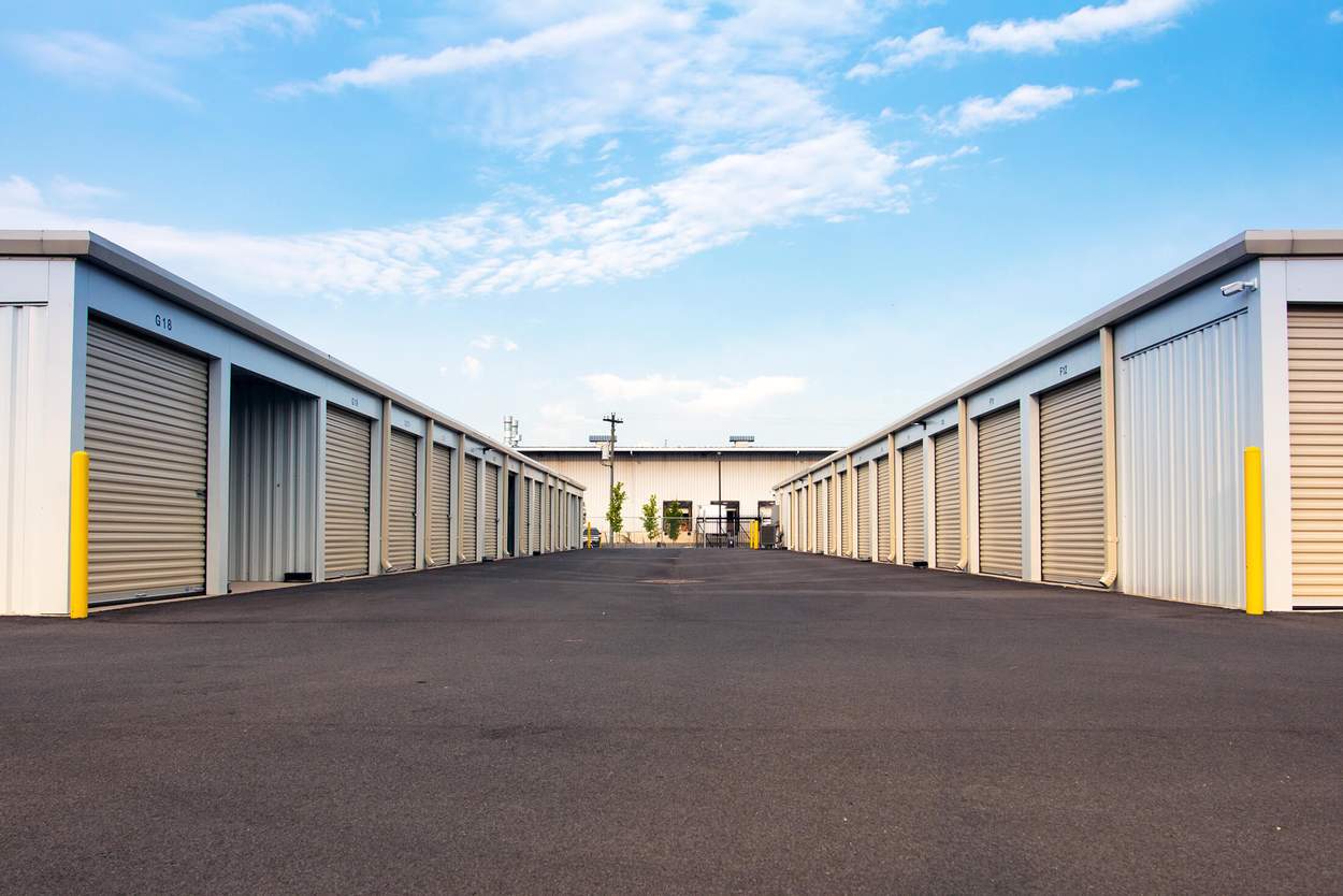 paved driveway between rows of drive up self storage facility