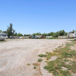 RVs and trucks parked at gravel storage lot
