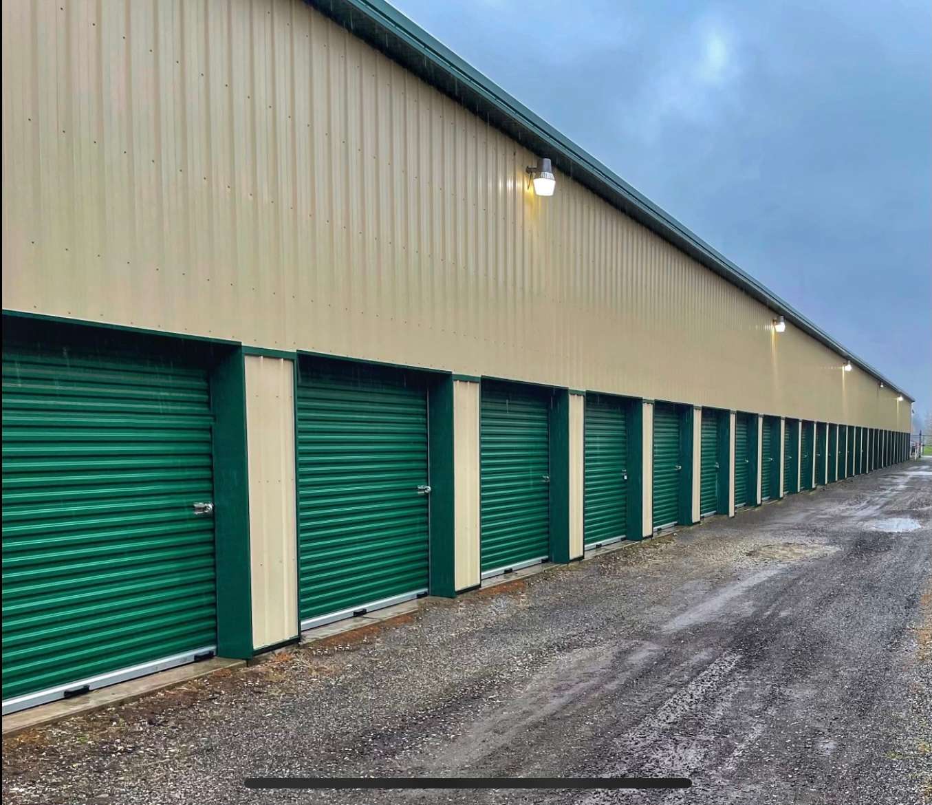 Self storage unit aisle with green doors