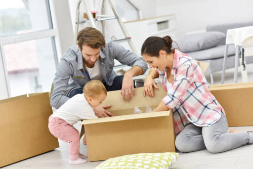 Family with Young Baby unpacking Boxes