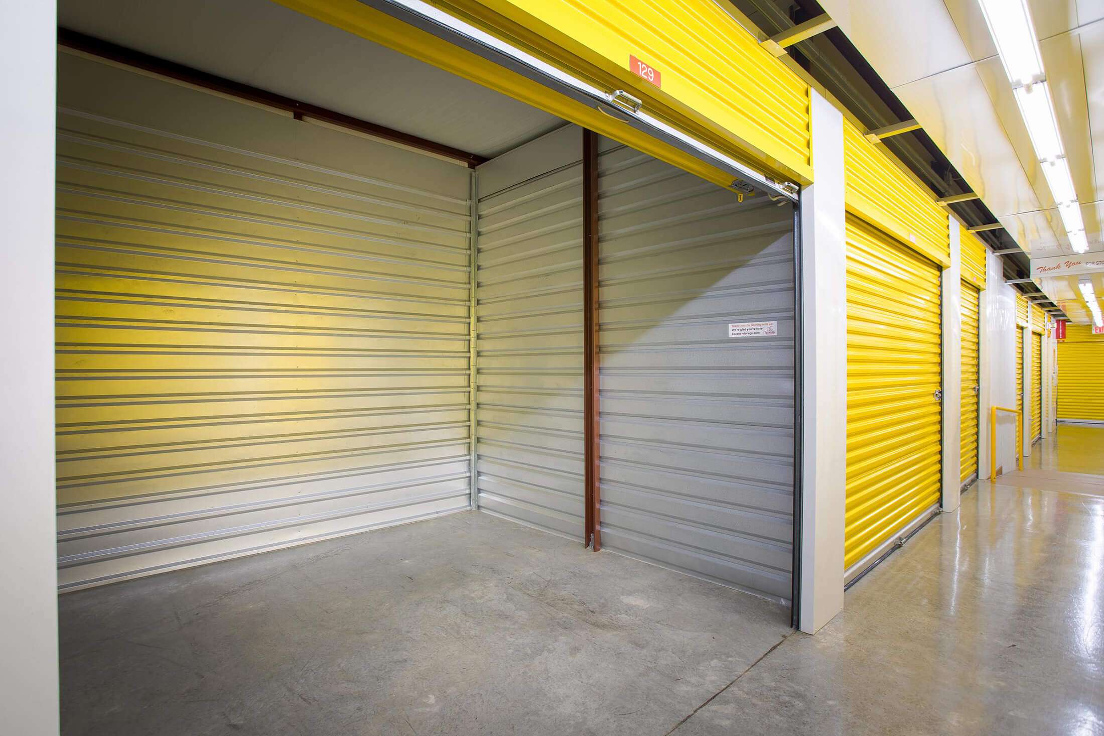 clean open unit in well lit hallway of climate controlled self storage