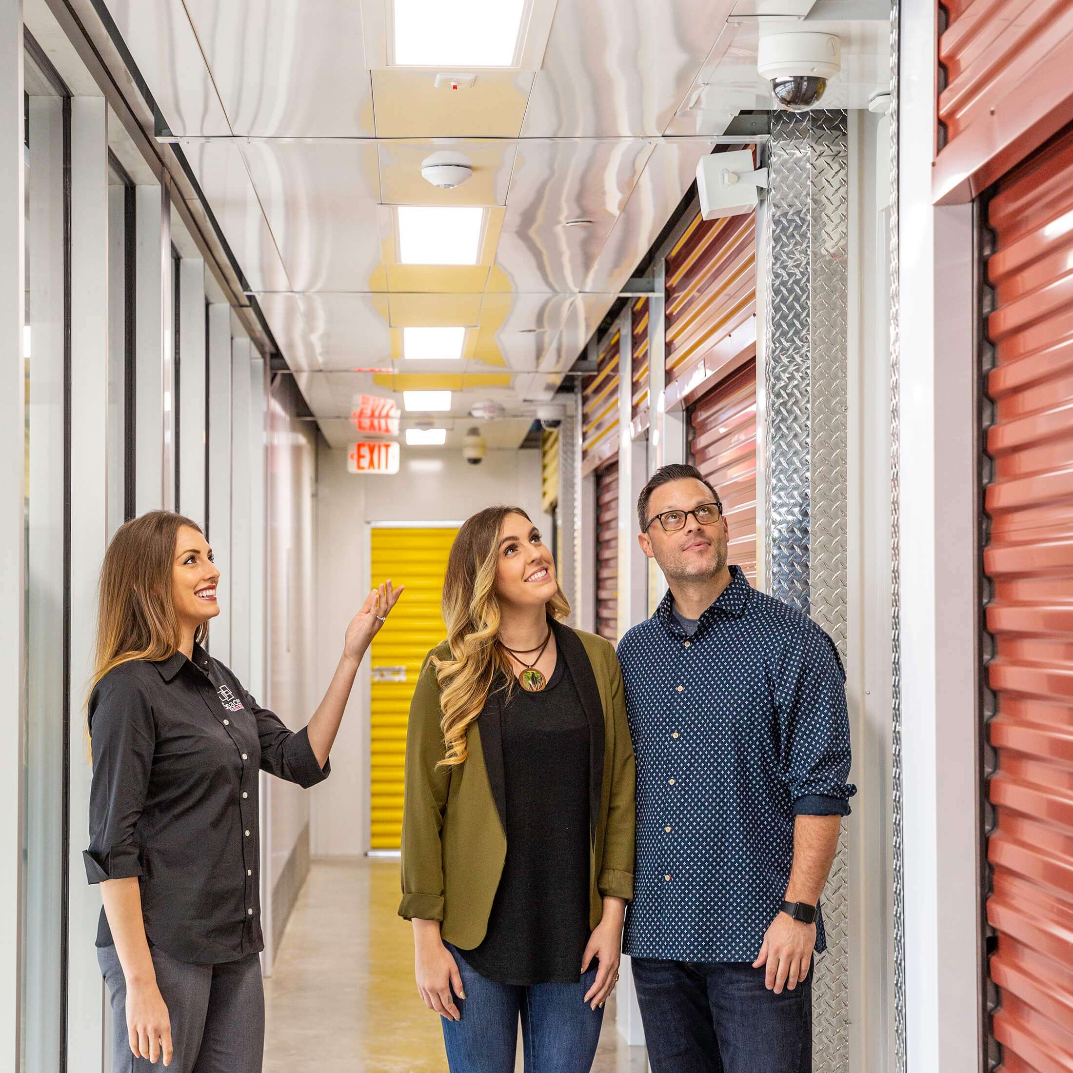 leasing agent showing customers security cameras at self storage facility